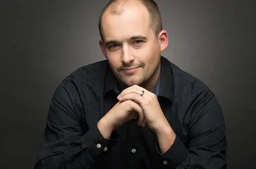 Austin Albany, Co-Founder and Creative Director at Sublime Media Group posing with hands under his chin