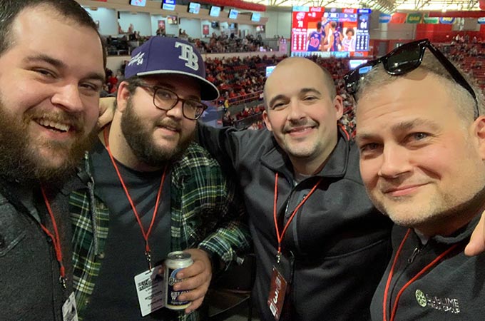 Sublime Media Group's Senior Website Developer Ross Brown, Marketing Strategist Will Kronenberger, Creative Director Austin Albany, and Managing Director Jon Doss posed together at a WKU Basketball home game