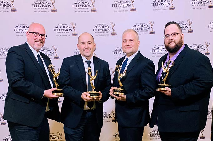 Sublime Media Group Emmy Award Winners David Hosay, Austin Albany, Jon Doss, and Will Kronenberger holding their trophies in front of a step and repeat wall at 2019 Ohio Valley Regional Emmy Awards
