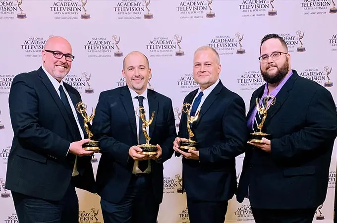 Sublime Media Group Emmy Award Winners David Hosay, Austin Albany, Jon Doss, and Will Kronenberger holding their trophies in front of a step and repeat wall at 2019 Ohio Valley Regional Emmy Awards