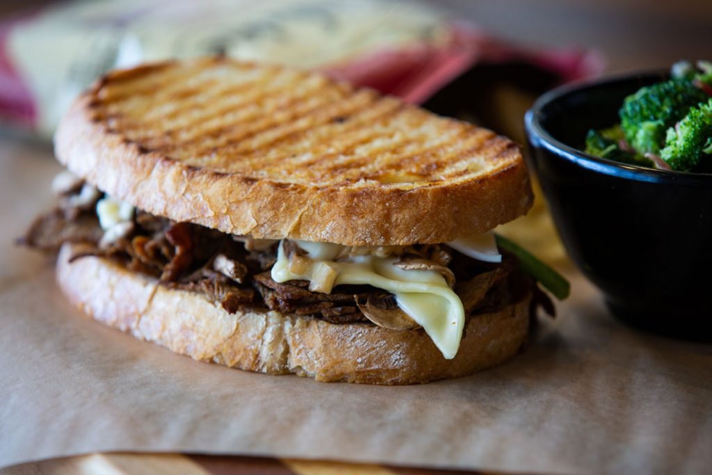 Griffs panini sitting on a table next to a side of vegetables