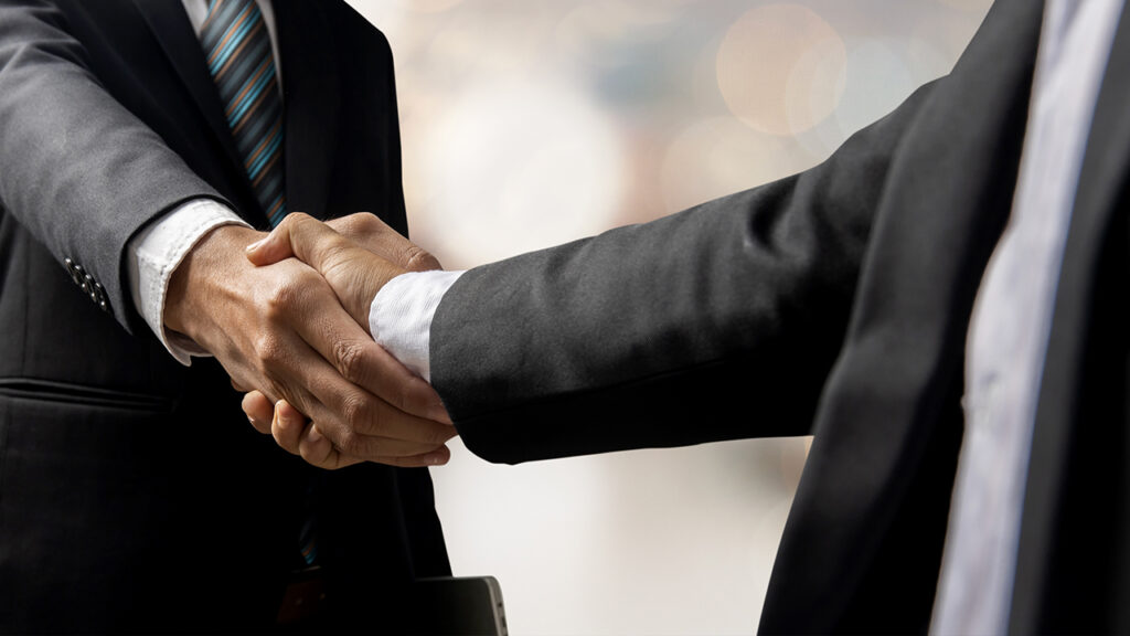 two men in suits shaking hands