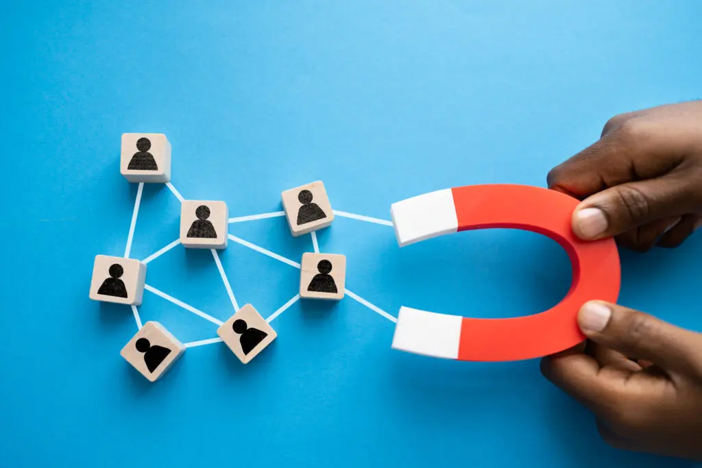 hands holding a magnet to attract top talent to symbolize recruiting talented people to work an industrial job