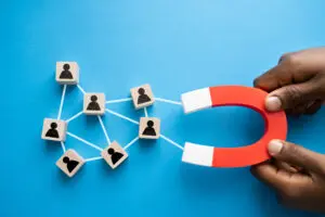 hands holding a magnet to attract top talent to symbolize recruiting talented people to work an industrial job